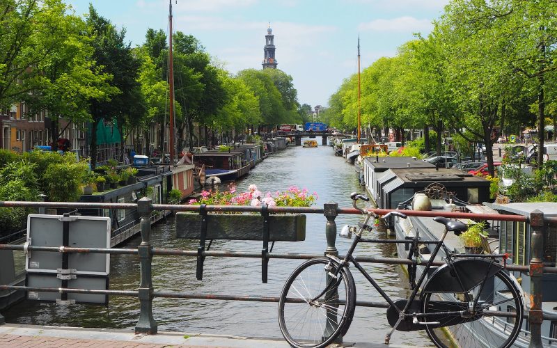 black city bike parked beside river during daytime